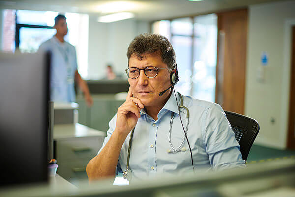 Doctor on a phone headset concentrating on a laptop