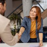 A woman working with legal firms shaking hands with a man in a suit