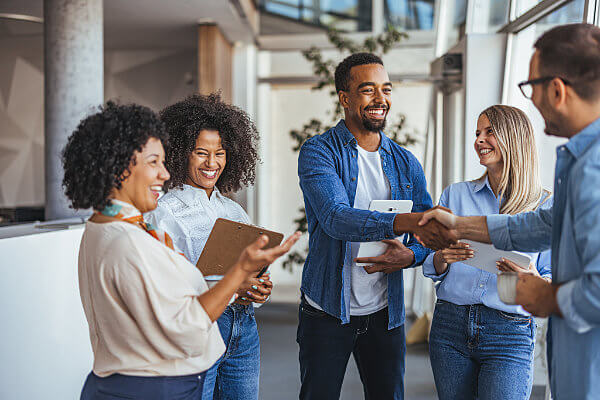Team of five happy people signing on to a UCaaS wholesale partner program