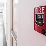 Close up of a red fire alarm in a professional building hallway