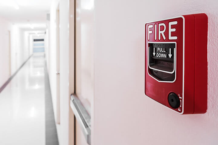 Close up of a red fire alarm in a professional building hallway