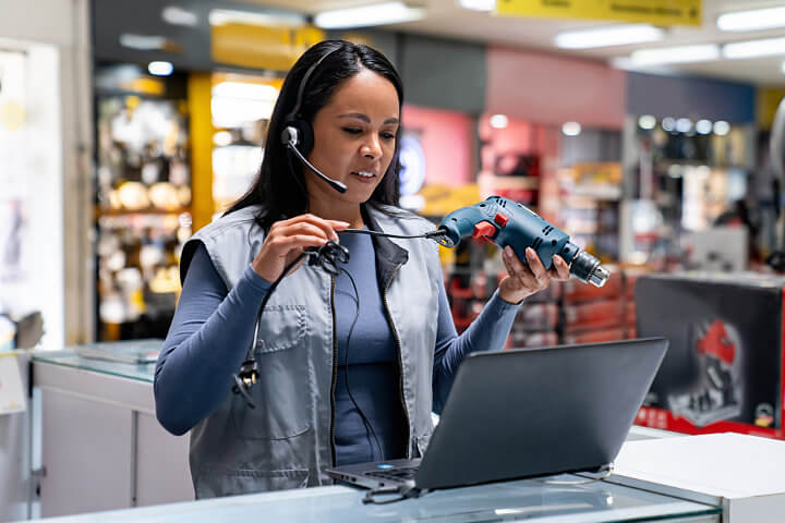 Woman providing customer support for a drill at a hardware store using an IP phone system