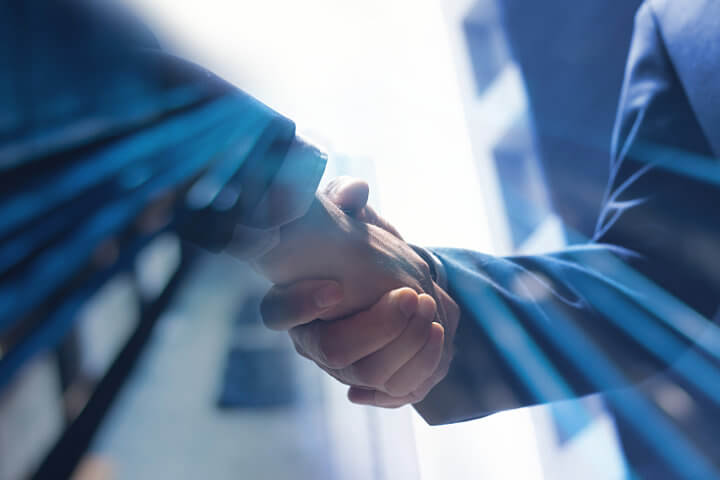 Close up of two business men shaking hands to represent FluentStream's partner program