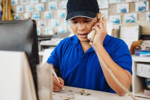FluentStream is a VoIP provider for small business like this man using a phone at his store's front counter