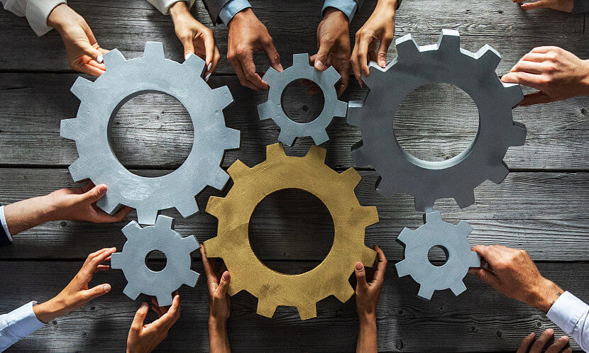 Team members moving various sized gears together to represent ConsultNet as a Channel Partner with Fluentstream.