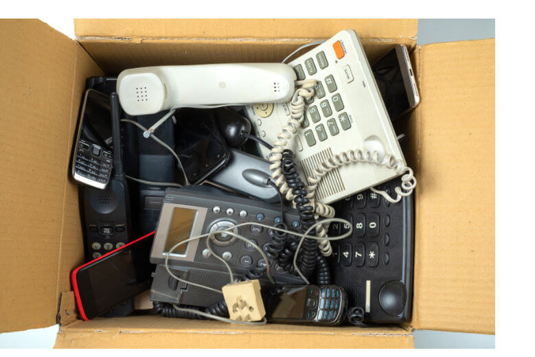 Looking down into a cardboard box of old phones