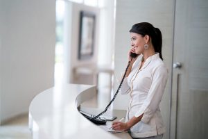 Woman in an open contemporary office space using a pbx phone system