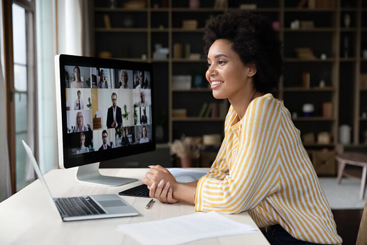 Young woman with a work from home job in a video meeting at her desk